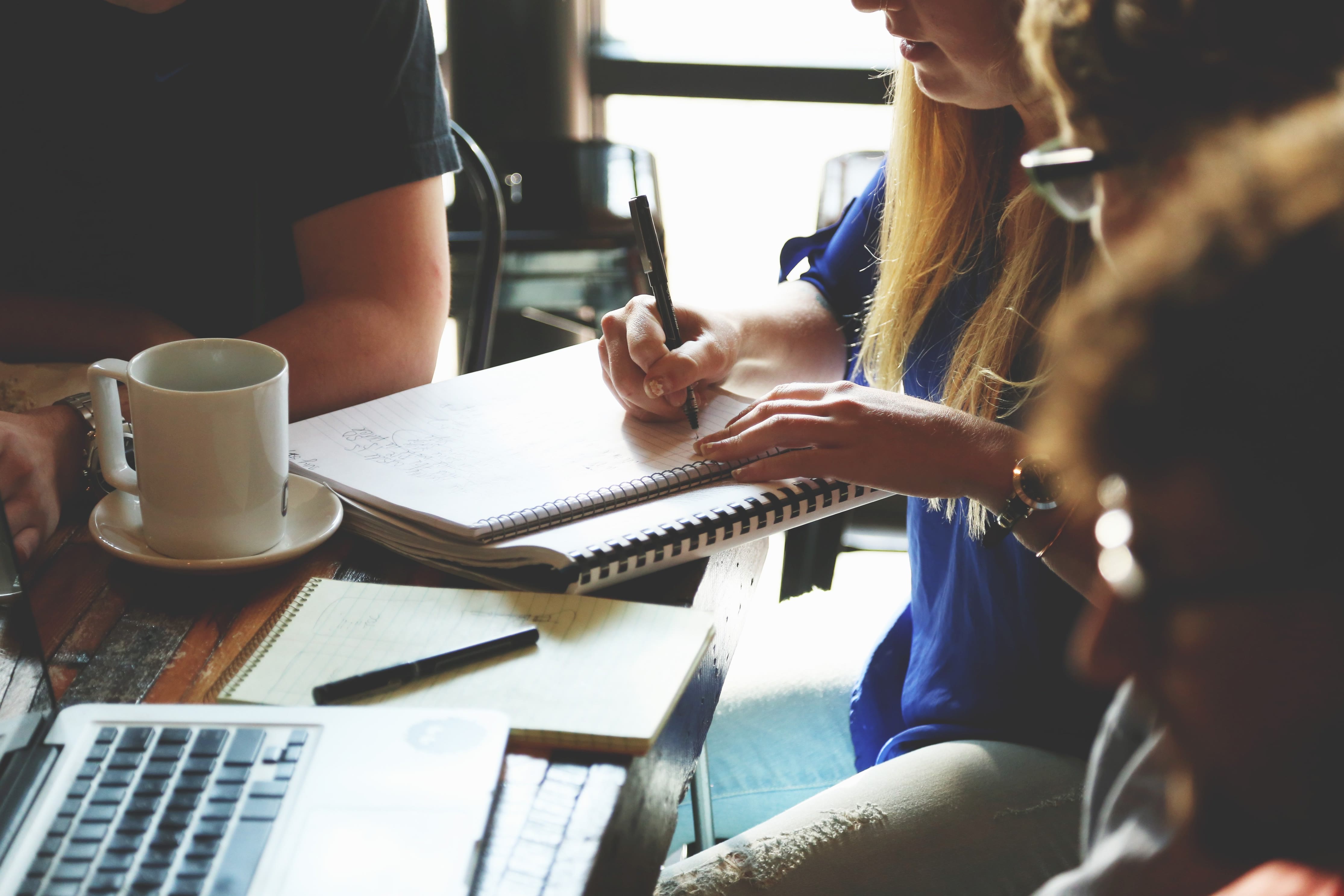 A small team reviewing findings together over notebooks